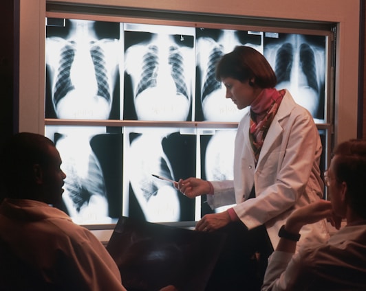 a doctor talking to a patient in front of a x - ray