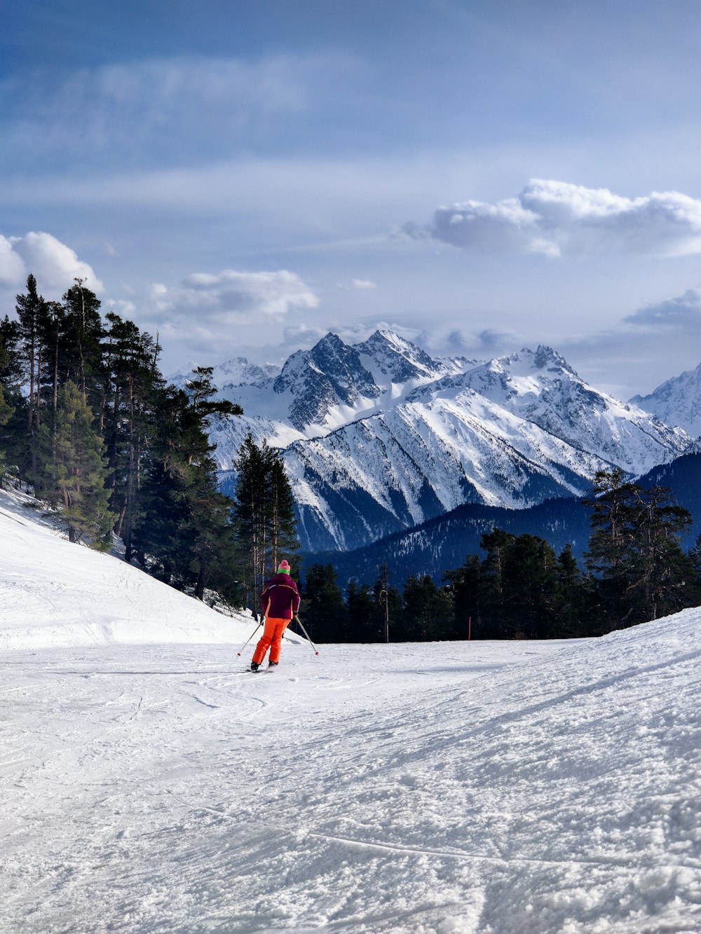 a person riding skis on top of a snow covered slope