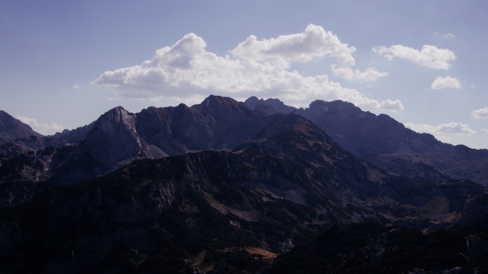 Une chaîne de montagnes avec quelques nuages dans le ciel