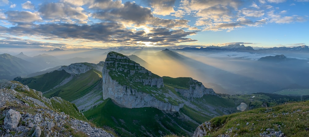 the sun is shining through the clouds over the mountains