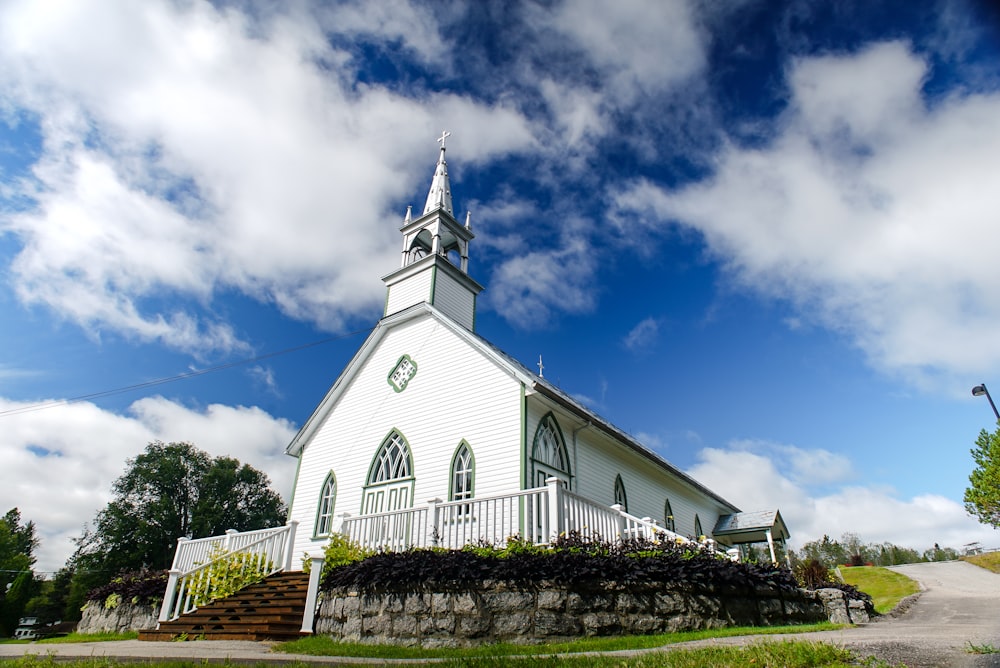 a white church with a steeple and a white fence