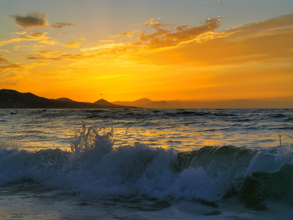 太陽は波で海に沈んでいます