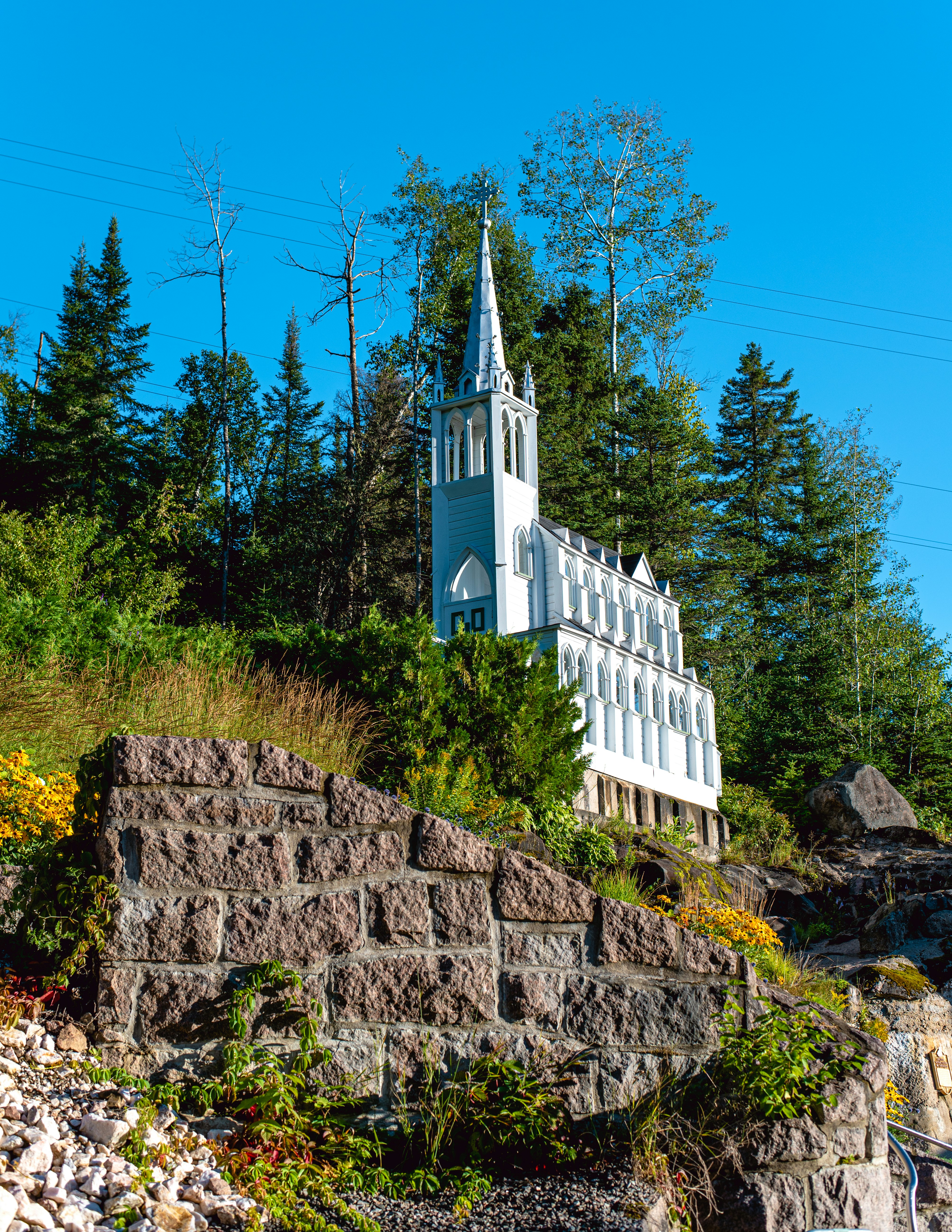 Une église blanche sur une colline avec des arbres en arrière-plan