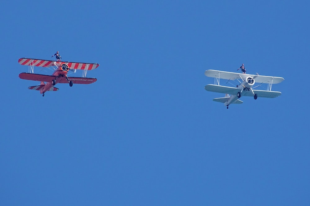 dois pequenos aviões voando lado a lado no céu