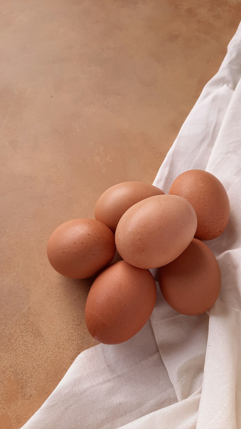 un mucchio di uova seduto sopra un panno bianco