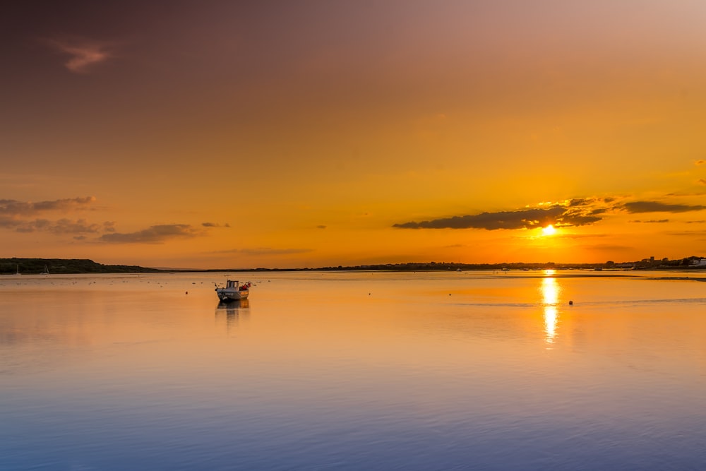 a small boat floating on top of a large body of water