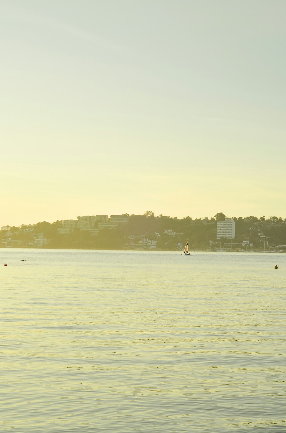 a body of water with a sailboat in the distance