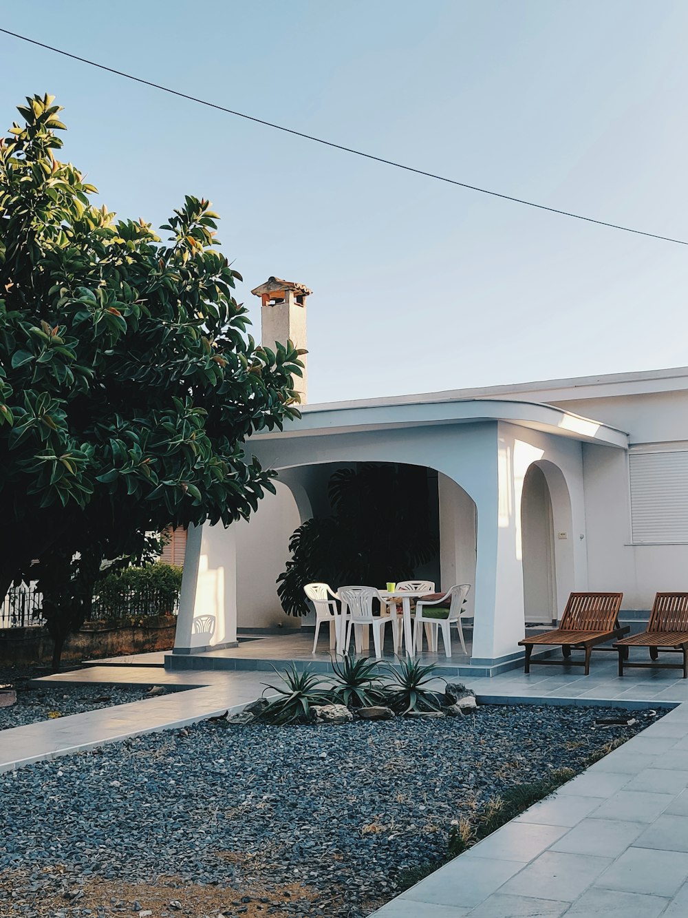 a patio with a table and chairs next to a tree