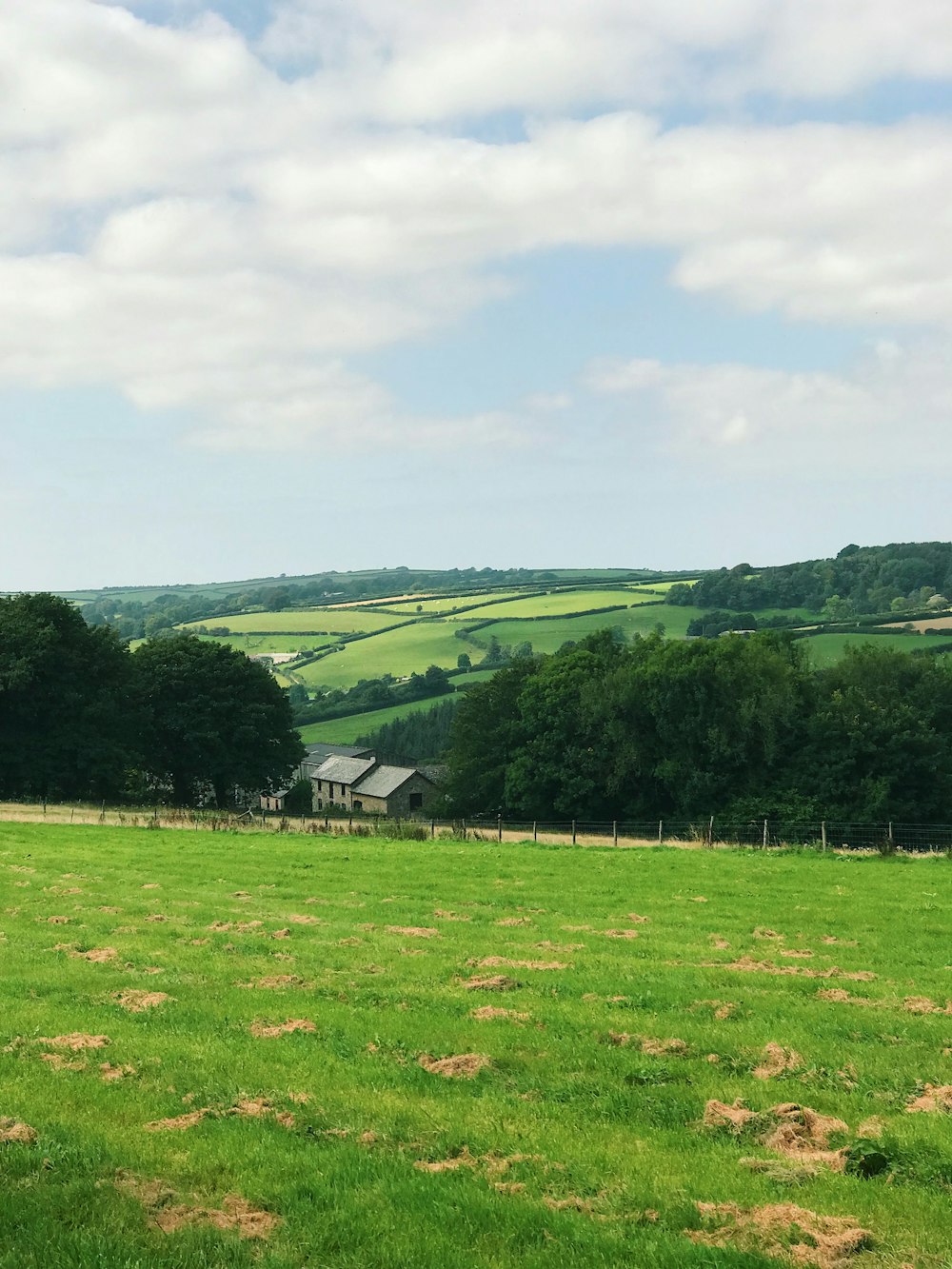 a green field with a house in the distance