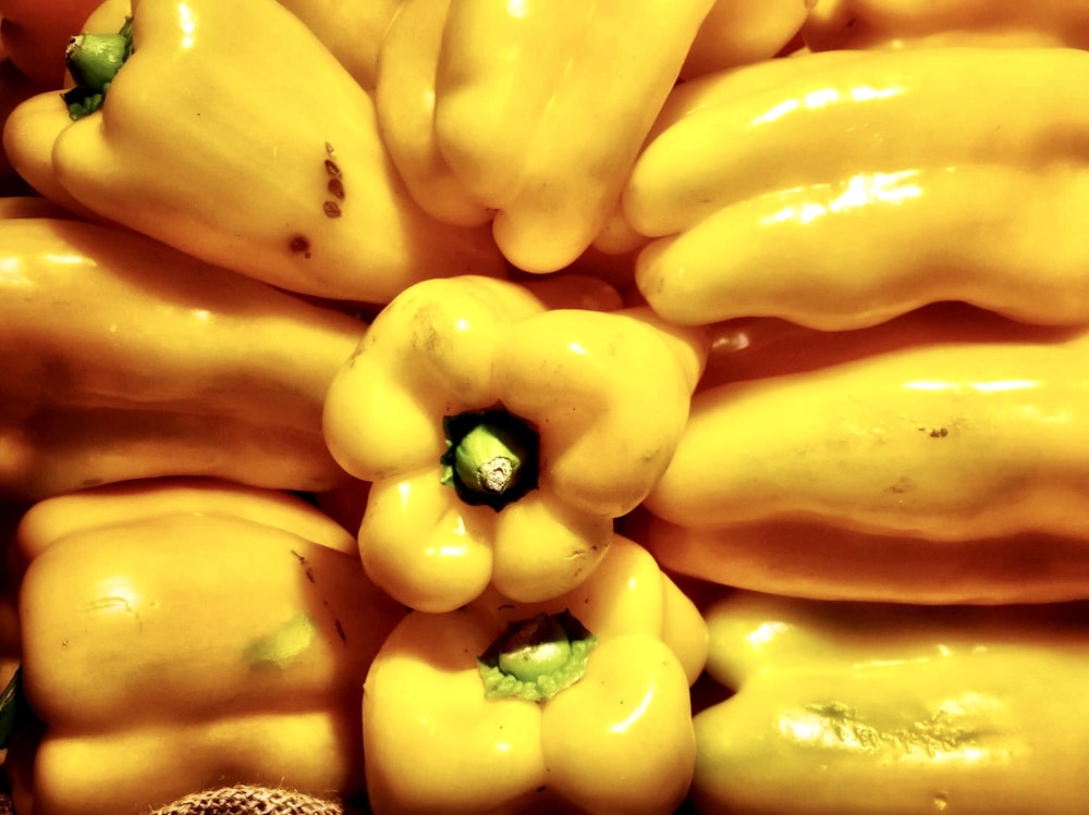 a pile of yellow peppers sitting on top of each other