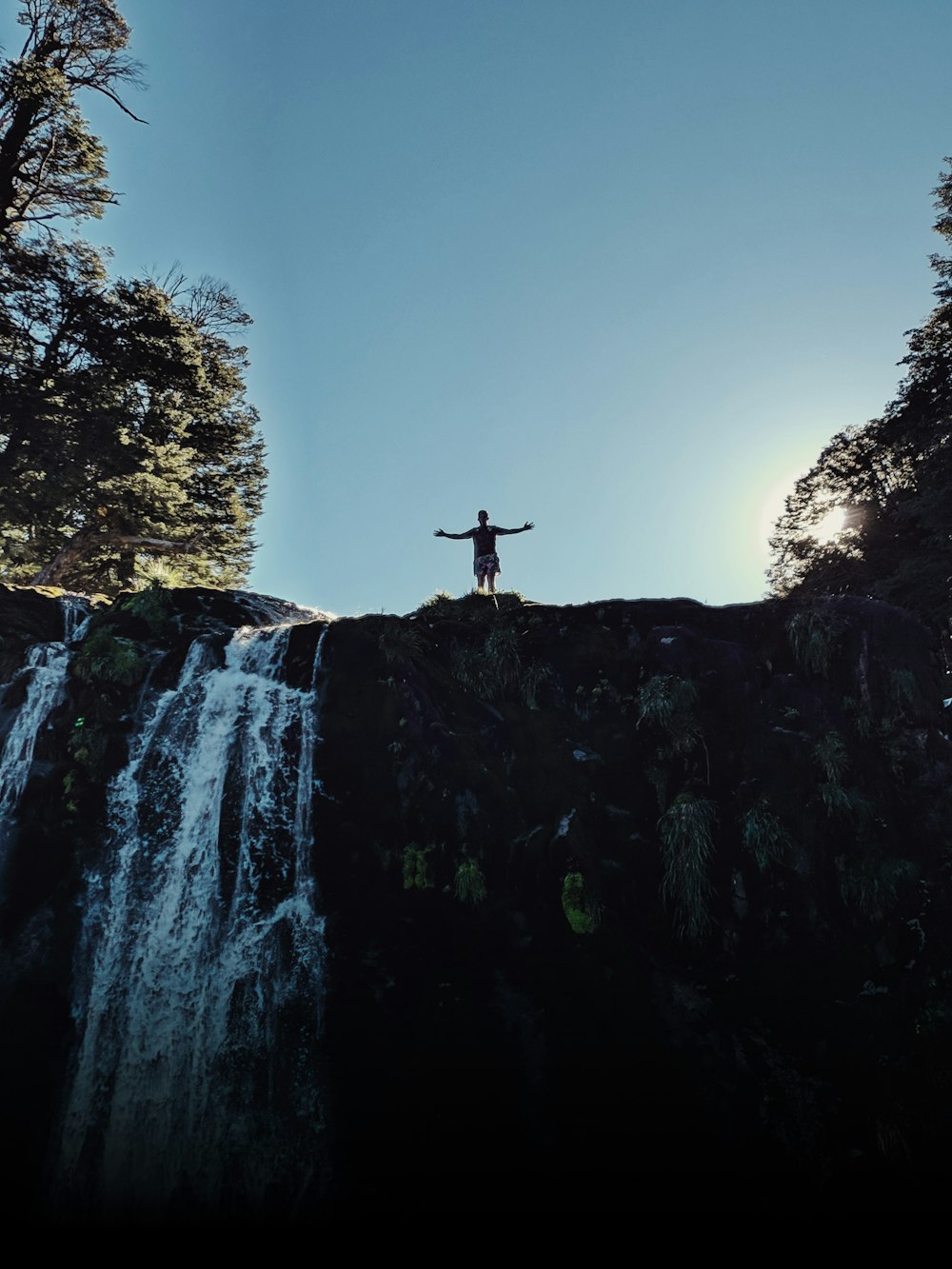 a person standing on top of a waterfall