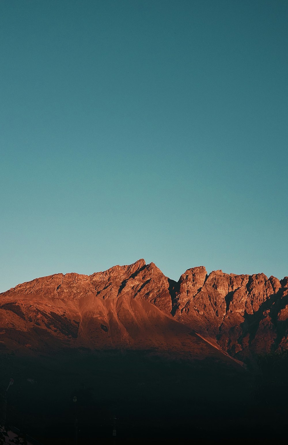 a plane flying over a mountain range at sunset