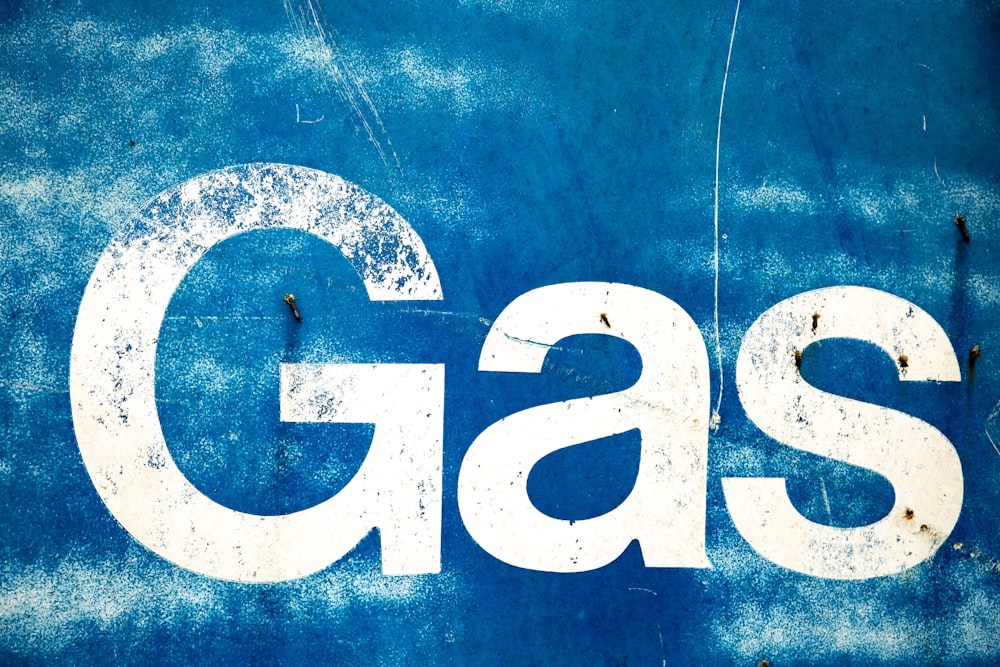 La palabra gas pintada en el costado de una pared azul