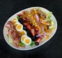 a white plate topped with a salad and hard boiled eggs