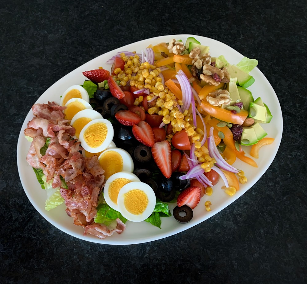 a white plate topped with a salad and hard boiled eggs