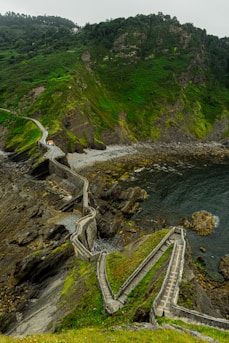 a scenic view of a rocky coastline with steps leading to the water