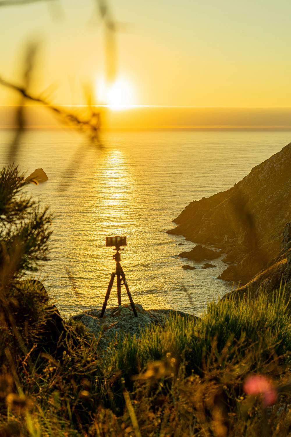 a telescope on top of a hill near the ocean