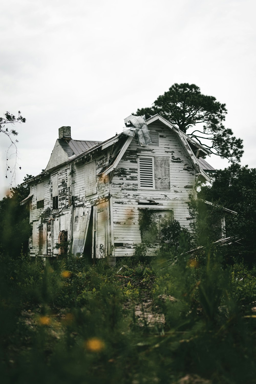 an old run down house in the middle of a field