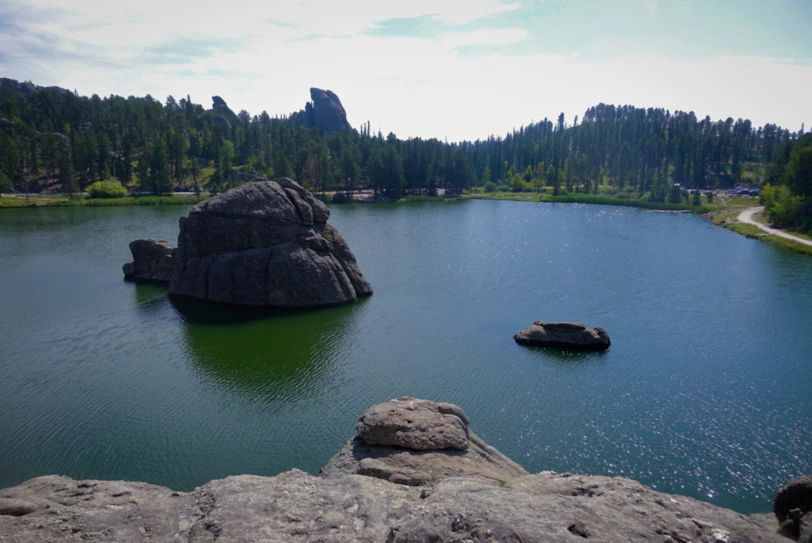 a body of water surrounded by rocks and trees