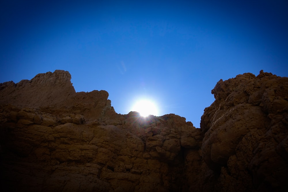 the sun shines brightly through the rocks in the desert