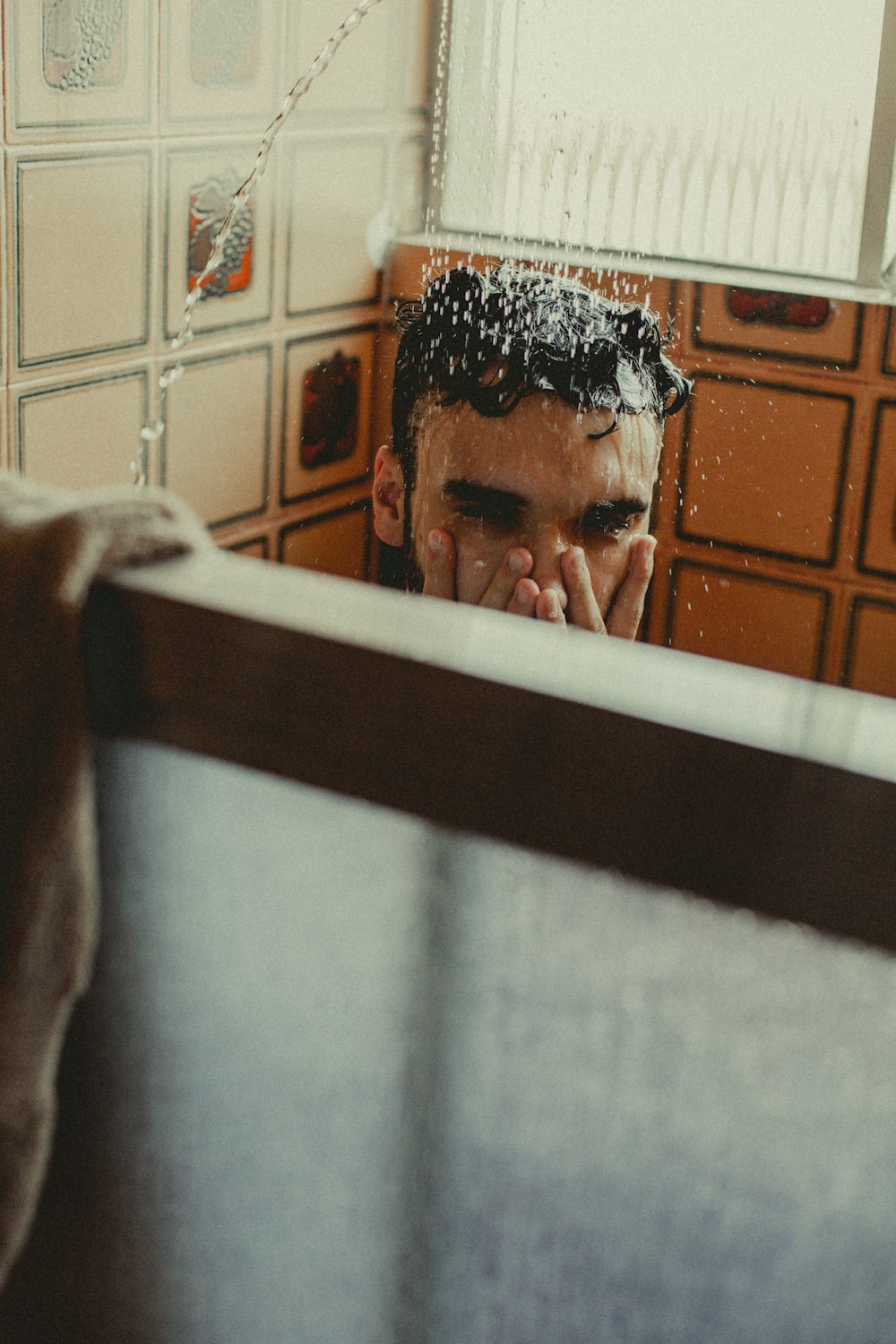 a man in a bath room looking at himself in the mirror