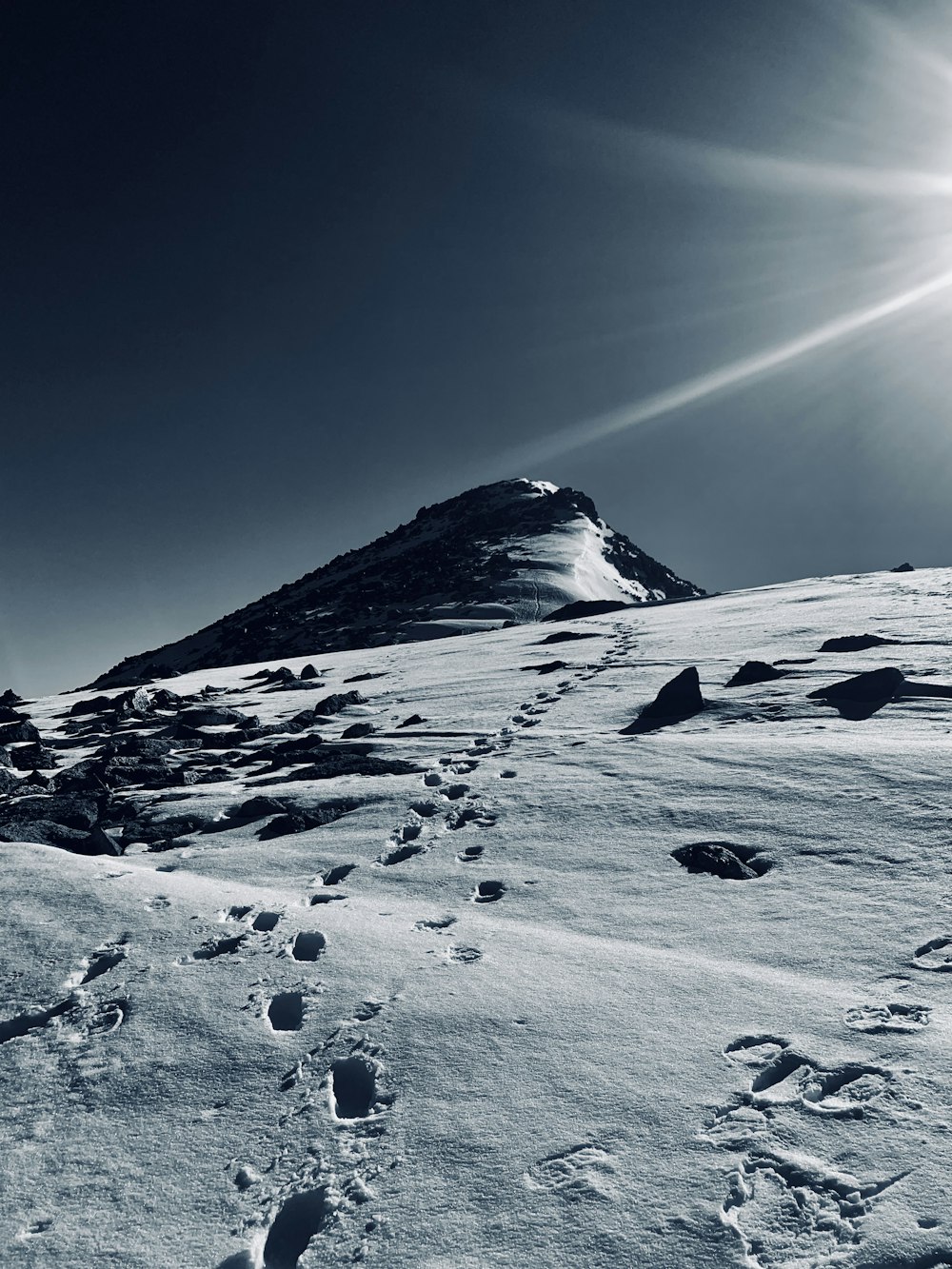 a snow covered mountain with footprints in the snow