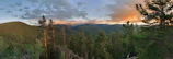 Panoramic view of lush forest and rustic cabins at sunset in Tena, Colombia.