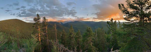 Panoramic view of lush forest and rustic cabins at sunset in Tena, Colombia.