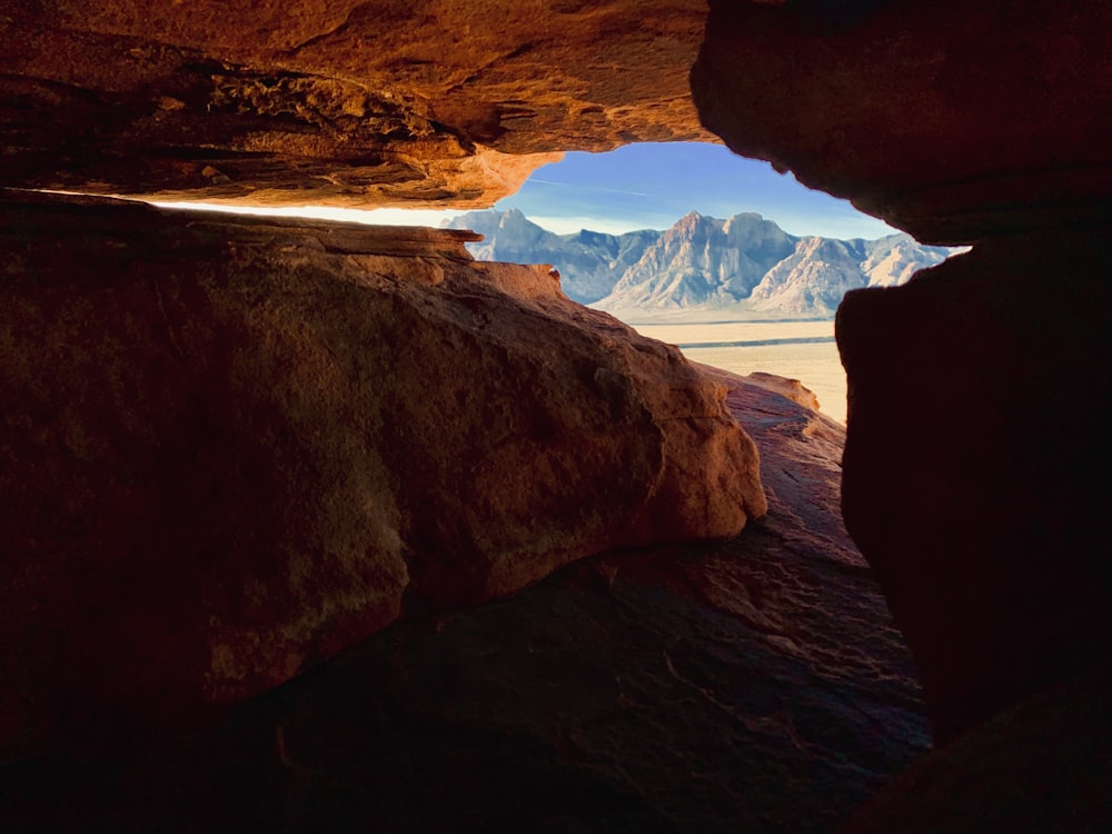 a view of mountains from inside a cave