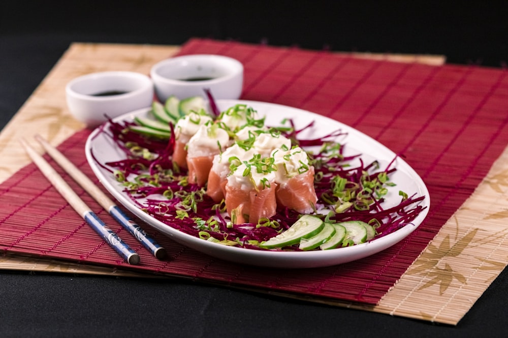 a white plate topped with sushi and cucumbers