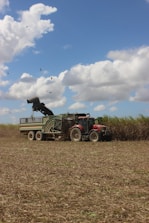 a tractor pulling a trailer with a cow on it
