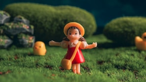 a little girl is standing in the grass