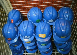 a bunch of blue helmets sitting on top of a metal rack