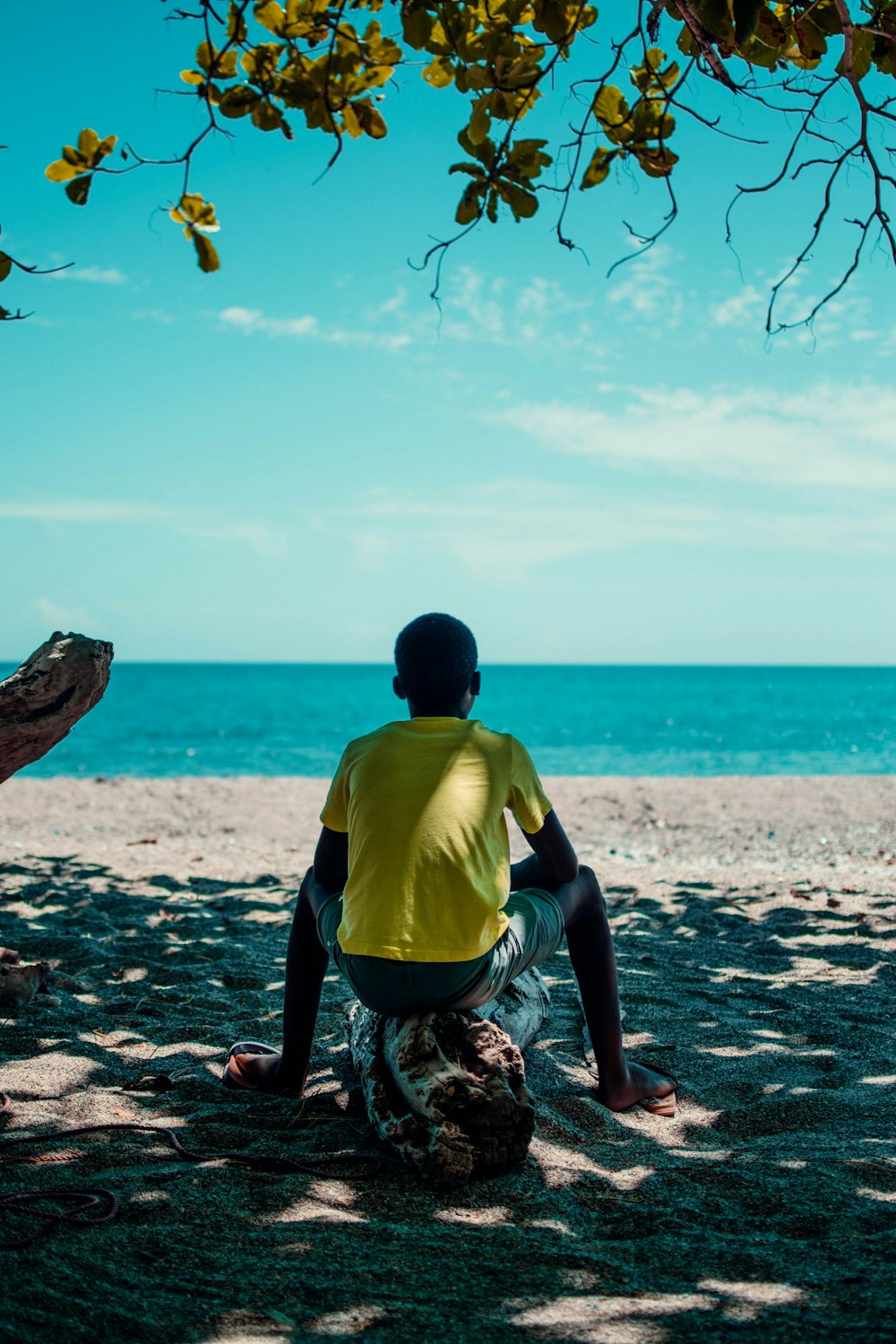 Ein Mann sitzt an einem Strand am Meer