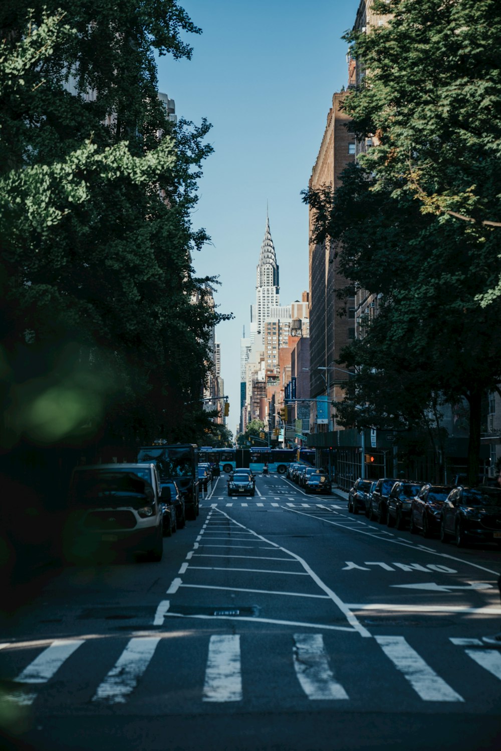 a city street lined with parked cars and tall buildings