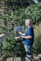 A person painting a vibrant landscape outdoors on a sunny day.