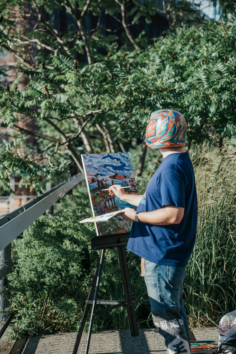 a man standing in front of a painting on a easel