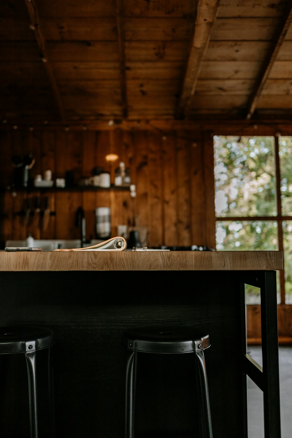 a kitchen with two stools next to a counter