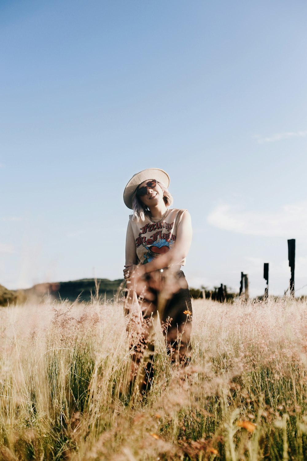 a woman standing in a field of tall grass