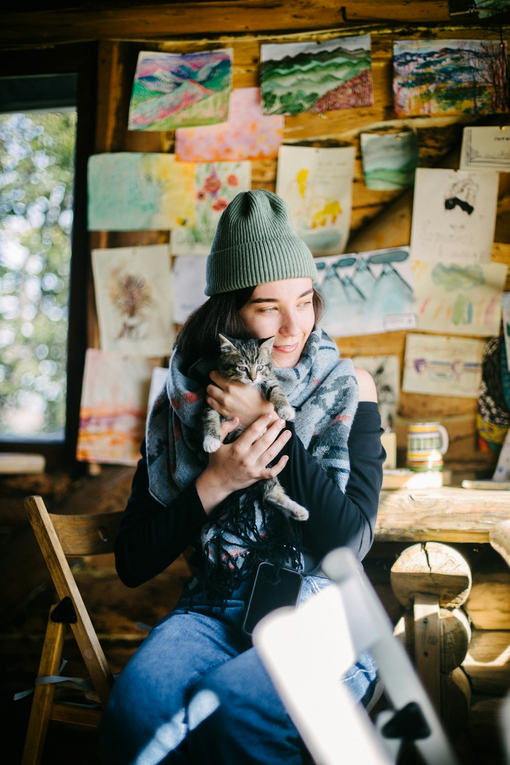 a woman sitting in a chair holding a cat