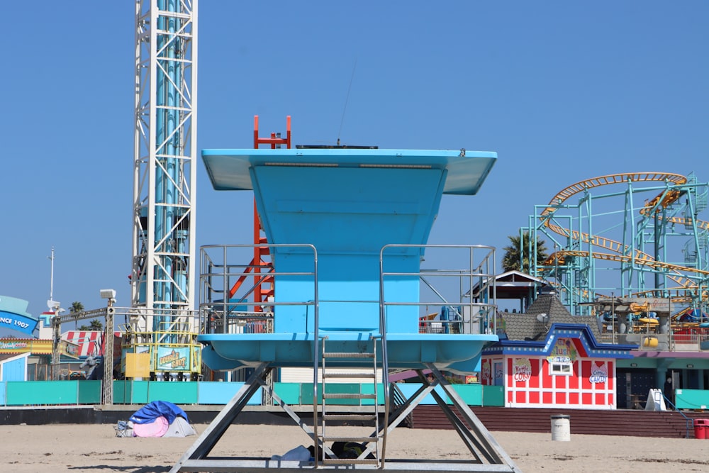 a blue lifeguard tower sitting on top of a sandy beach