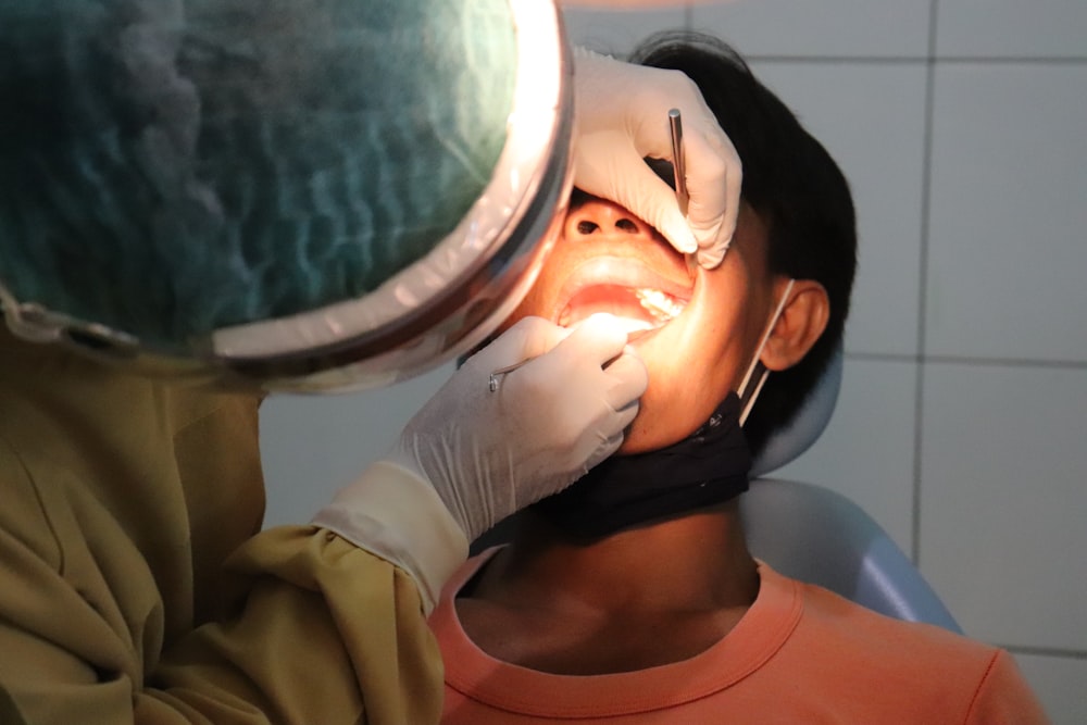 Un hombre que se hace revisar los dientes por un dentista