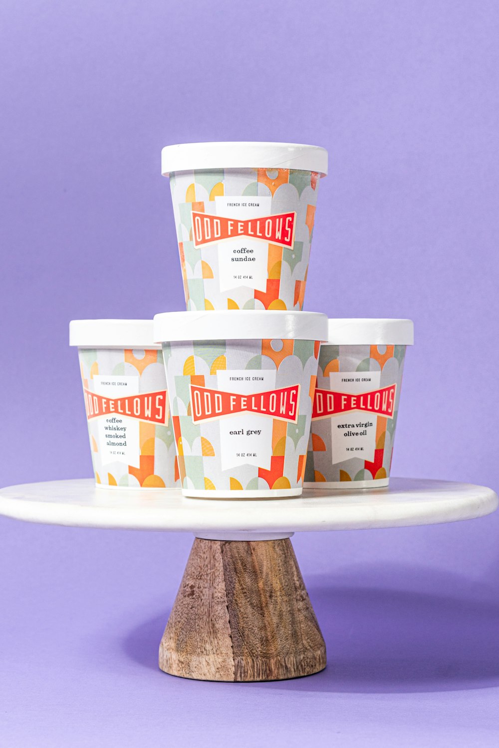 four ice cream cups sitting on top of a cake plate