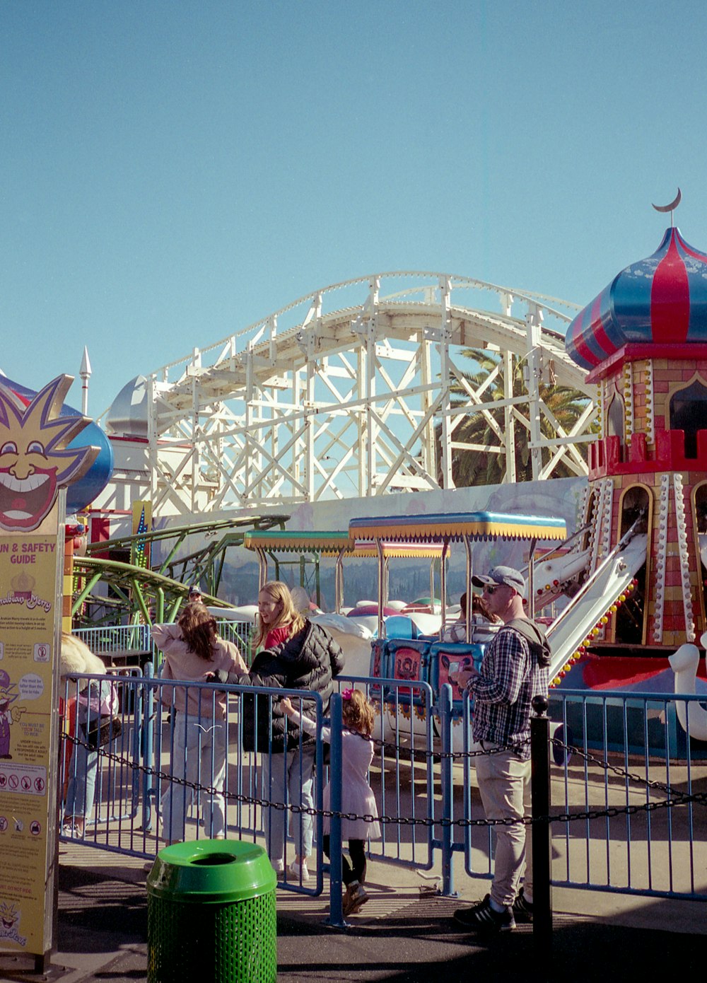 a group of people standing around a carnival ride