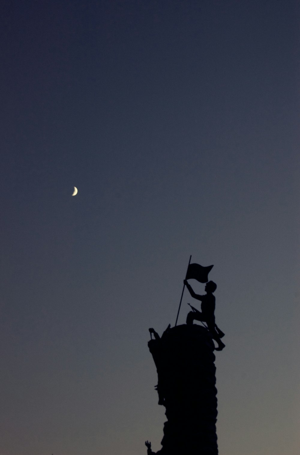 a statue with a flag on top of it