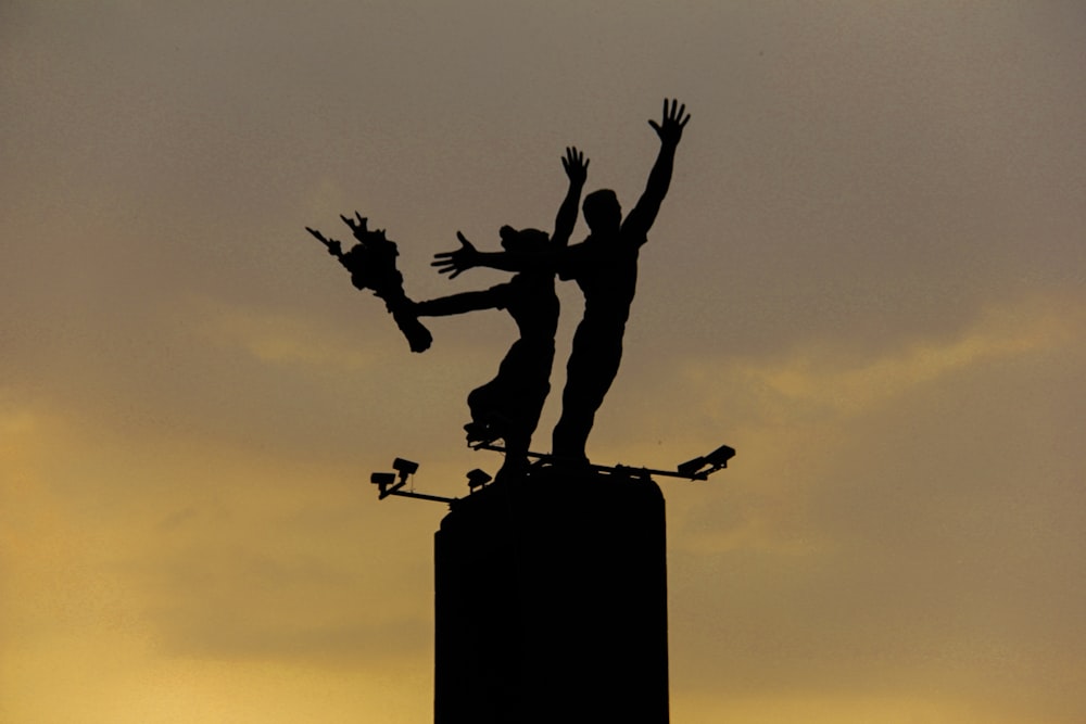 a statue of a man on a skateboard on top of a pole