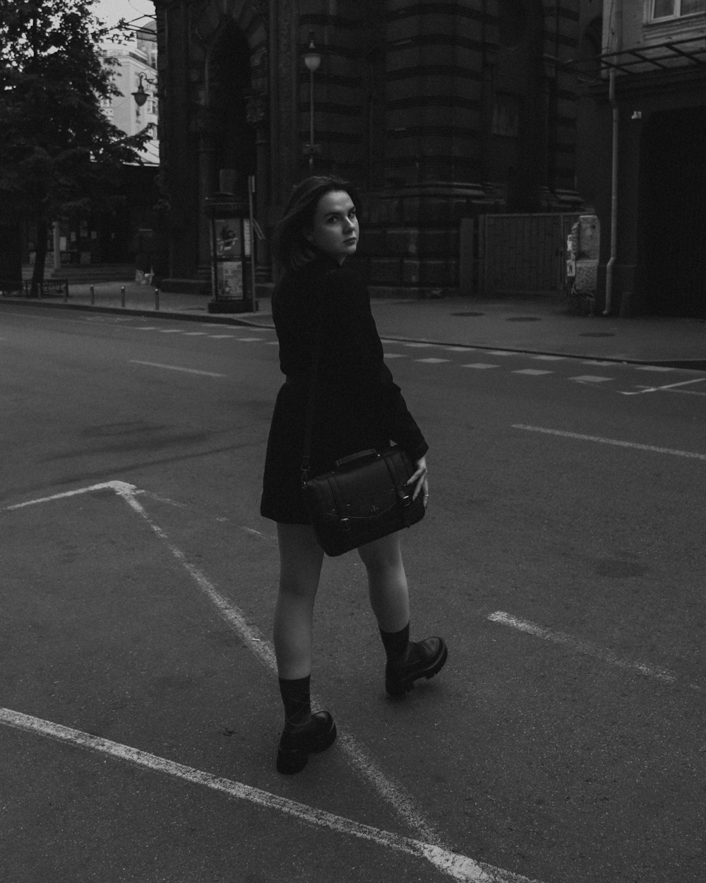 a woman standing in the middle of a parking lot