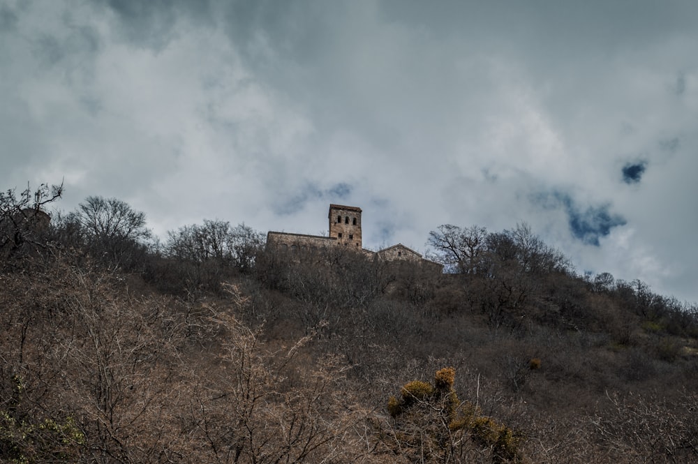 a church on a hill with a cloudy sky in the background