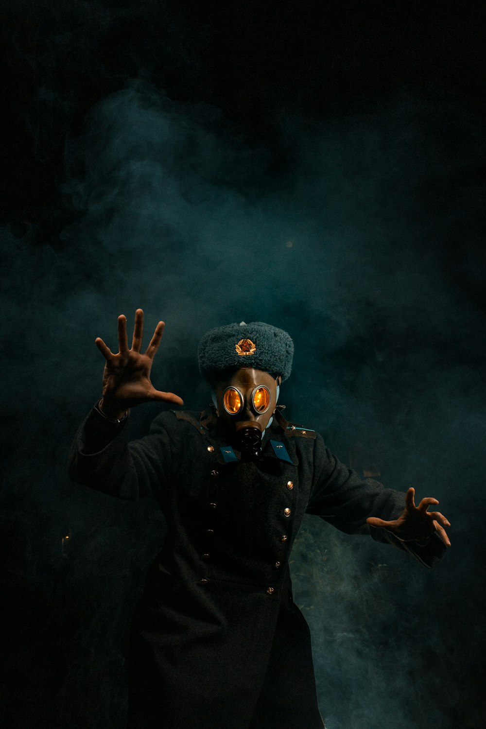 a man wearing a gas mask and holding his hands up