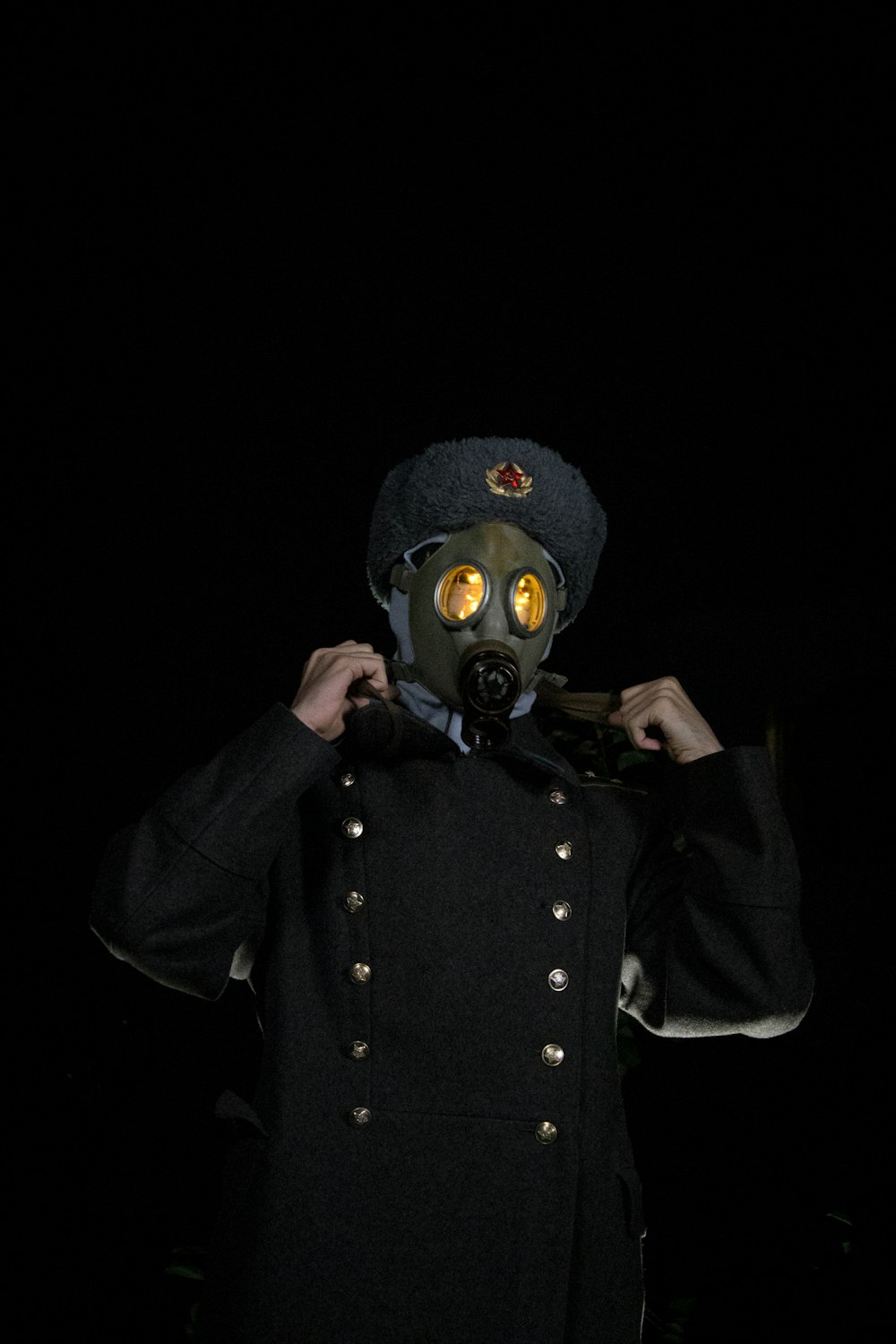 a man wearing a gas mask and a coat
